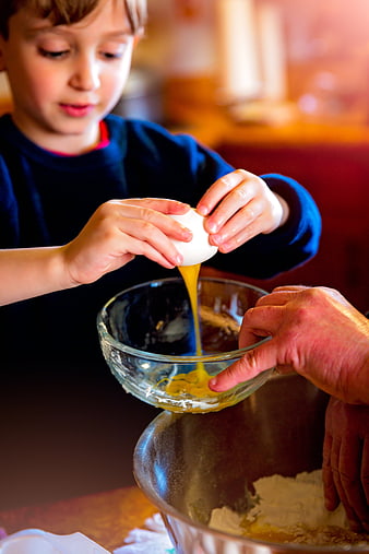 Child Cracking Egg into Bowl for Baking