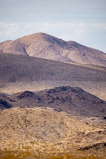 Layered desert mountains with arid terrain and blue sky