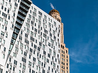 Modern White Building and Historic Tower Against Blue Sky