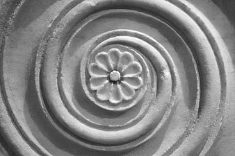 Black and white close-up of carved stone flower relief