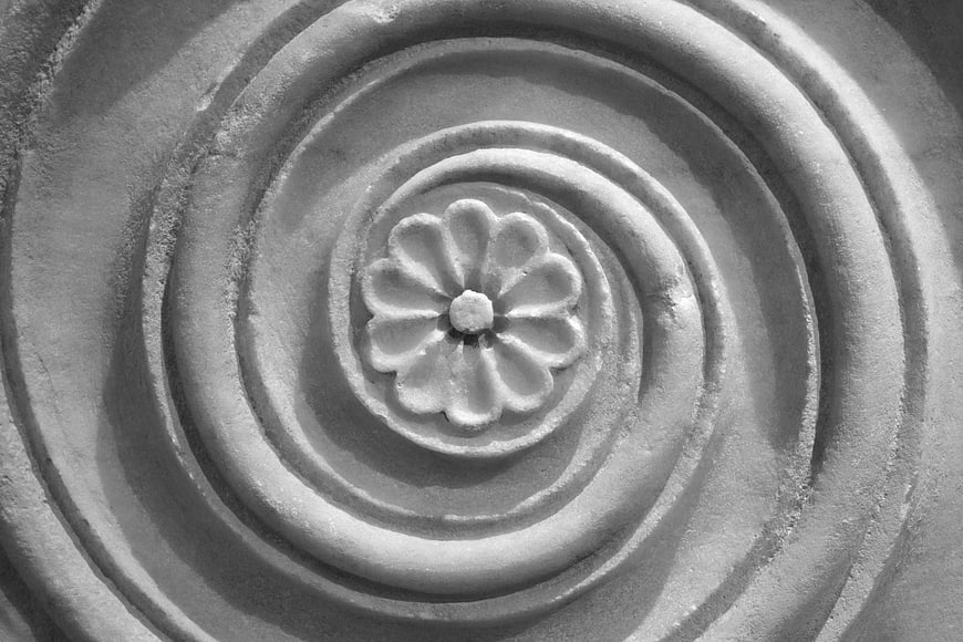 Black and white close-up of carved stone flower relief