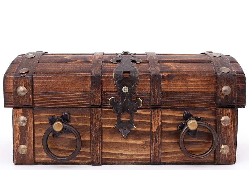 Vintage wooden treasure chest with metal hardware on white background