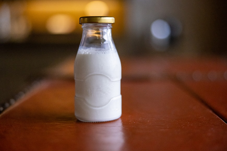 Glass Bottle of Fresh Milk on Wooden Table