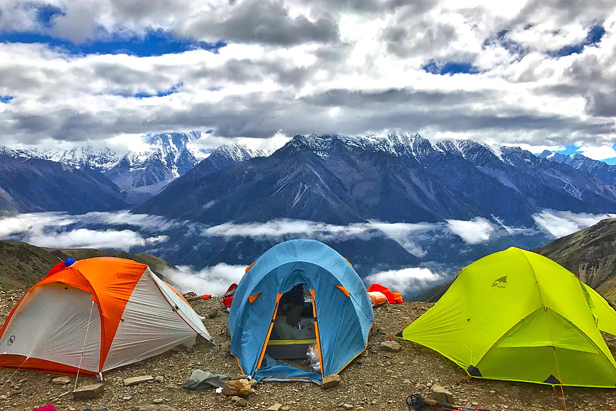 Colorful Camping Tents on Mountain Ridge with Snowy Peaks