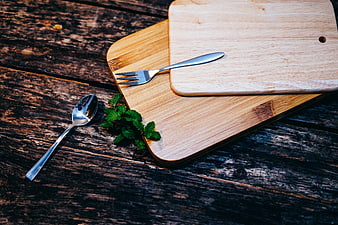 Wooden cutting boards with silverware and mint on rustic table