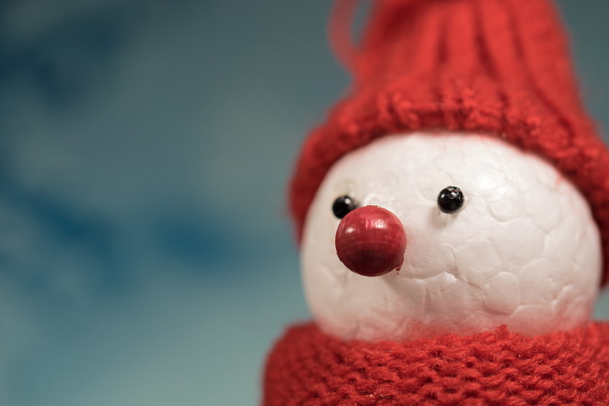 Close-up of handmade snowman with red hat and scarf