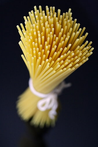 Close-up of raw spaghetti pasta bundle on black background
