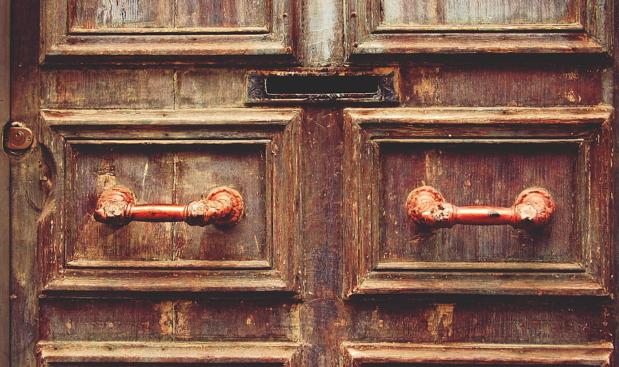 Vintage Wooden Door with Rusty Handles and Mail Slot