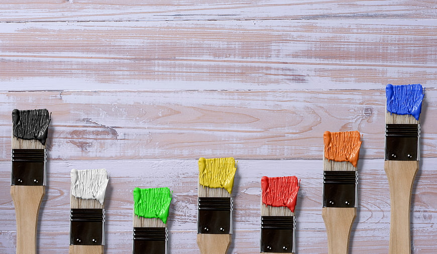 Colorful Paint Brushes on Whitewashed Wooden Background