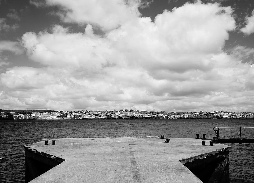 Black and white view of Lisbon from a concrete pier