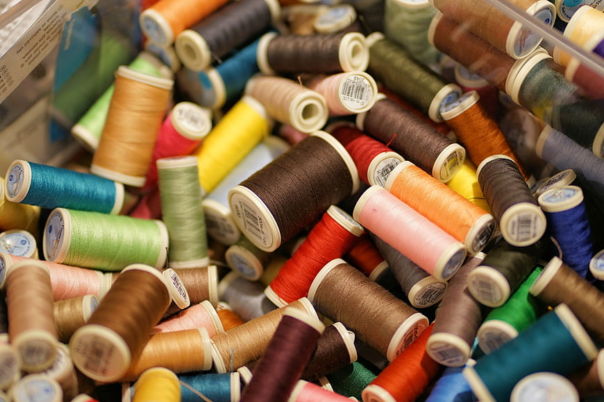 Colorful Spools of Sewing Thread in a Container