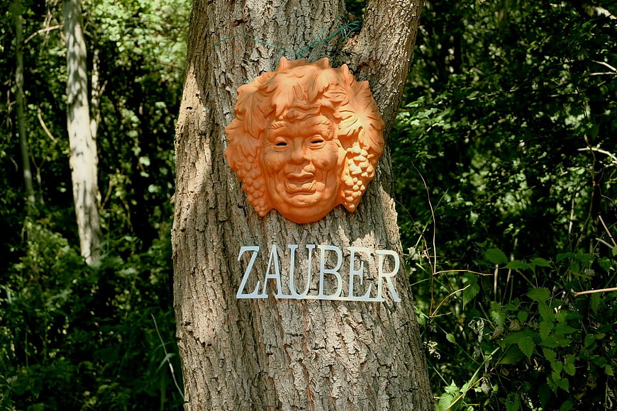 Orange Dionysus Mask on Tree with Zauber Sign in Forest