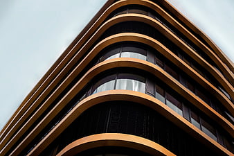 Modern curved building facade with golden balconies