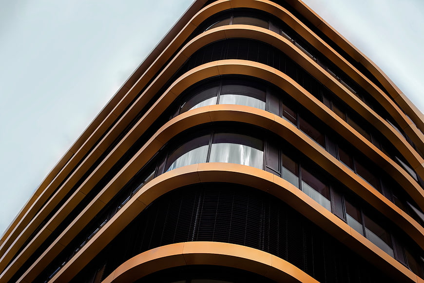 Modern curved building facade with golden balconies