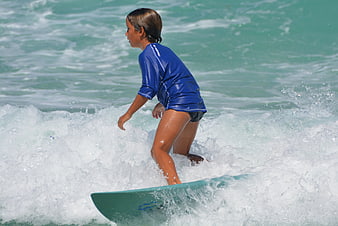Young boy surfing on a wave in the ocean