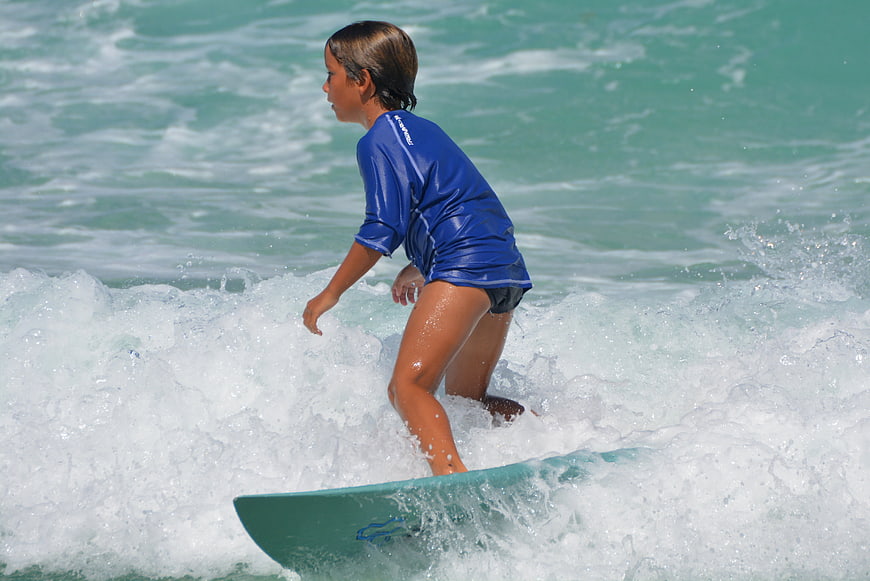 Young boy surfing on a wave in the ocean