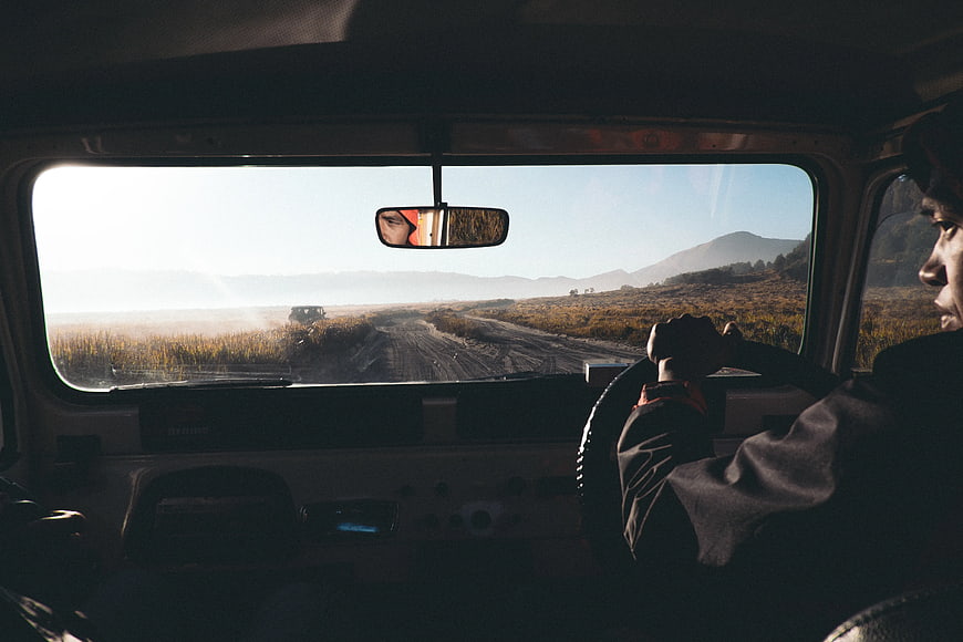 Man driving off-road vehicle through misty mountain landscape