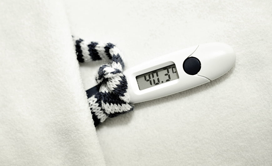 Digital Thermometer Under White Blanket Showing Fever Temperature