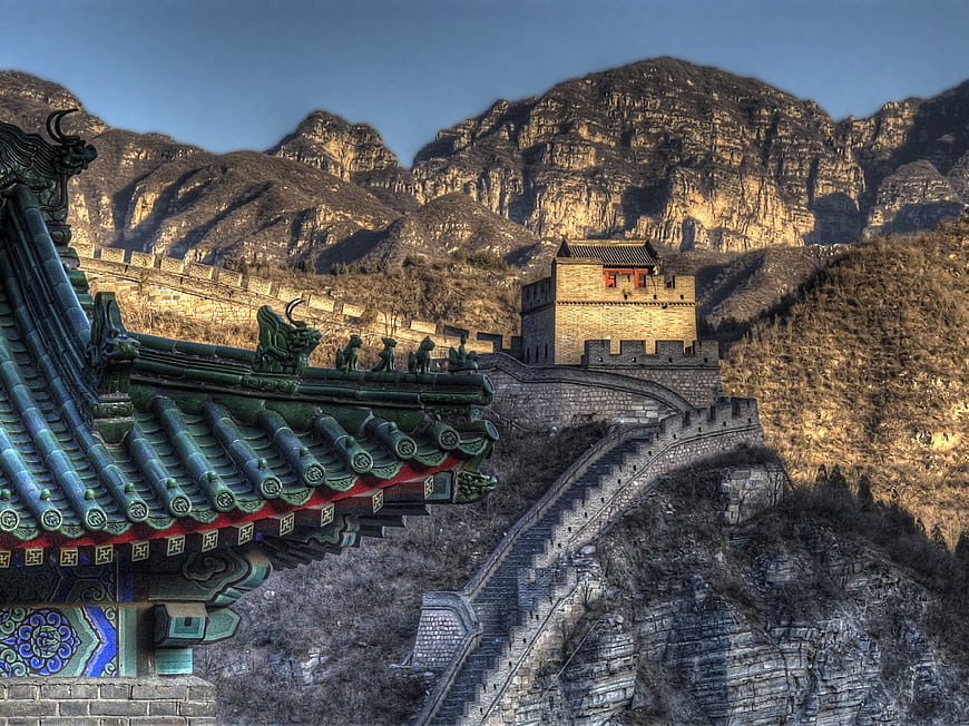 Great Wall of China with ornate temple roof and mountainous landscape