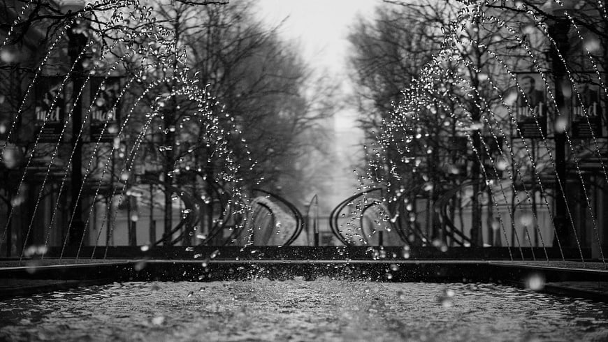 Black and white fountain with water droplets in winter park