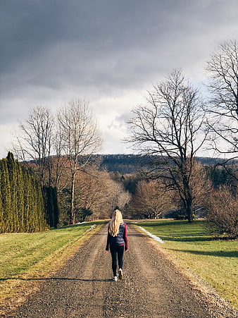 Woman Walking Away on Gravel Path in Nature