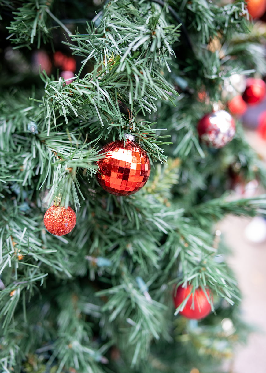 Close-up of red disco ball ornament on Christmas tree