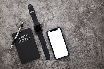 Flat lay of smartphone, smartwatch, and notebook on concrete