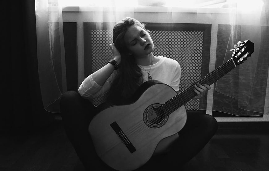 Woman Playing Acoustic Guitar in Black and White