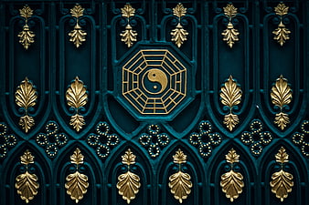 Ornate teal and gold gate featuring a central yin yang and bagua symbol