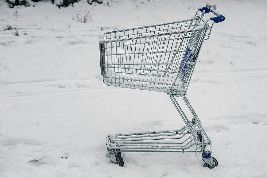 Empty Shopping Cart Abandoned in Snowy Field