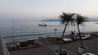 Relaxing beach resort scene at dusk with lounge chairs and sea view
