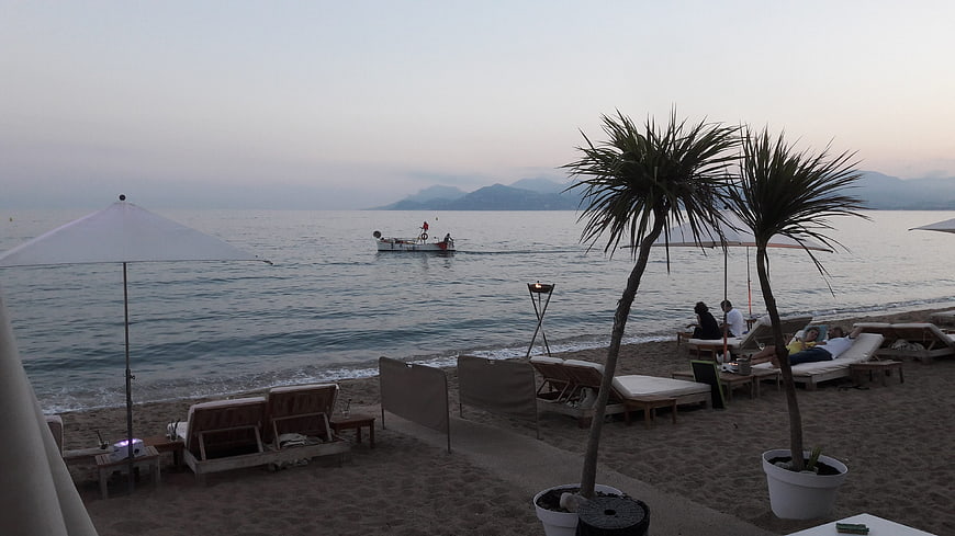 Relaxing beach resort scene at dusk with lounge chairs and sea view