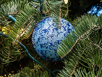 Close-up of Blue Glitter Christmas Ornament on Pine Tree