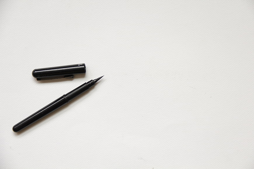 Black Calligraphy Pen on White Textured Paper Background