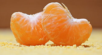 Close-up of peeled tangerine segments on textured surface