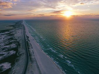 Aerial View of Coastal Road at Sunset Over Ocean