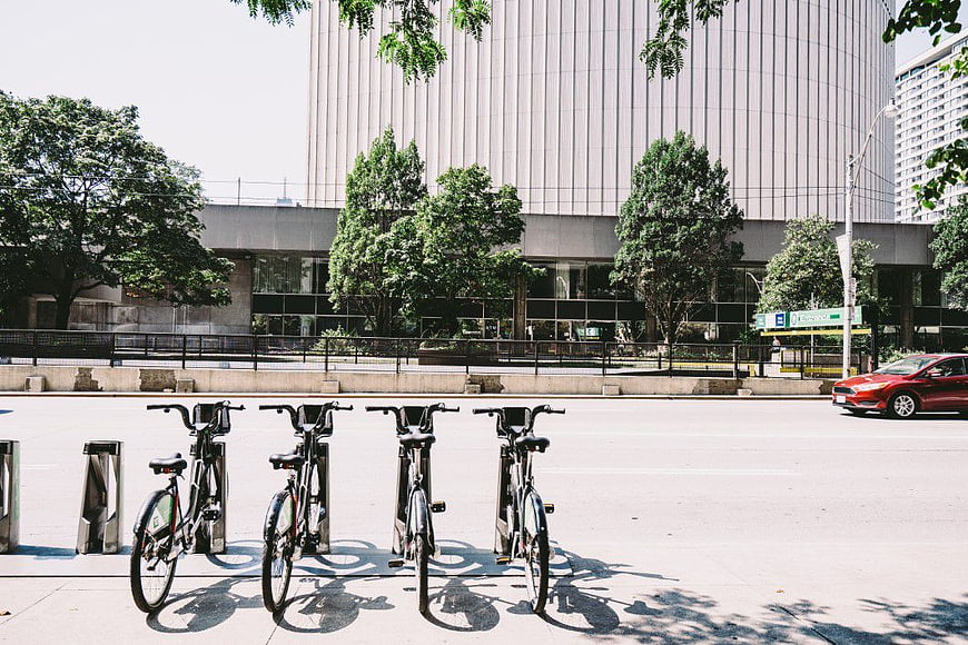 Row of Docked Bicycles on City Sidewalk