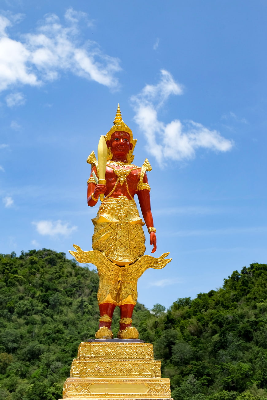 Golden Thai Guardian Deity Statue Against Blue Sky