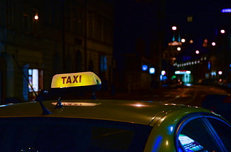 Yellow Taxi Roof Light on City Street at Night