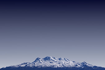 Snow-Capped Mountain Peak Against Clear Blue Sky