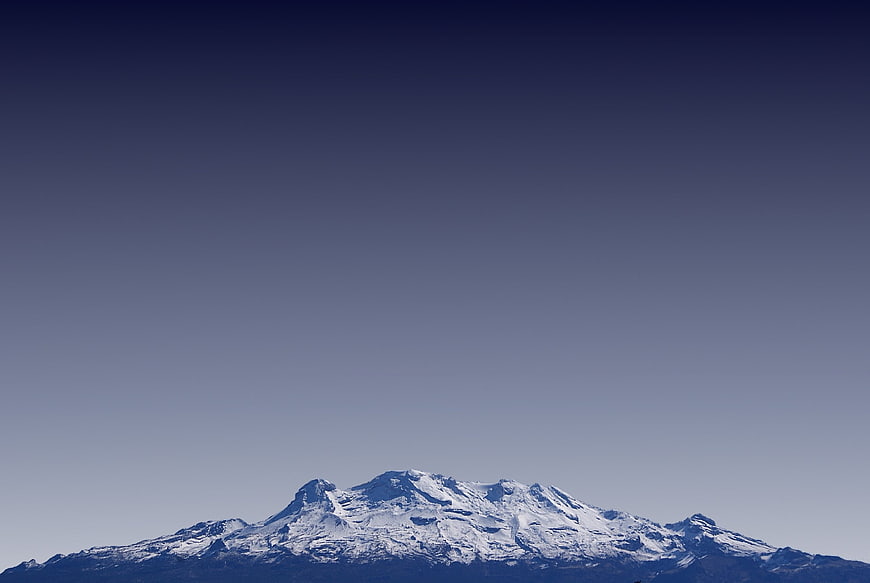 Snow-Capped Mountain Peak Against Clear Blue Sky
