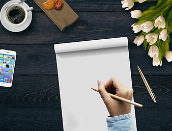 Hand Writing On Blank Paper With Coffee, Tulips, And Smartphone On Dark Wood