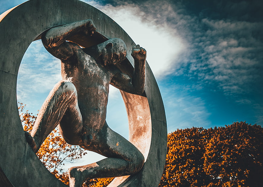 Bronze Atlas Sculpture in Circle Against Blue Sky