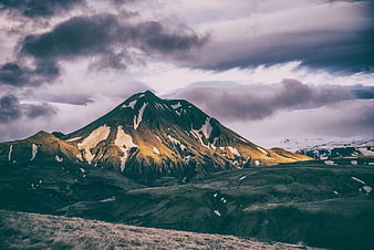Dramatic Snow-Capped Mountain Peak Under Cloudy Sky