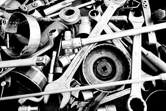 Black and white pile of assorted metal tools and wrenches