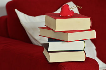 Stack of Books with Red Heart on Red Sofa