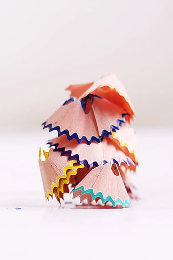 Colorful pencil shavings pile on white background
