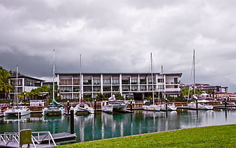 Modern Marina with Yachts and Resort Buildings Under Cloudy Sky