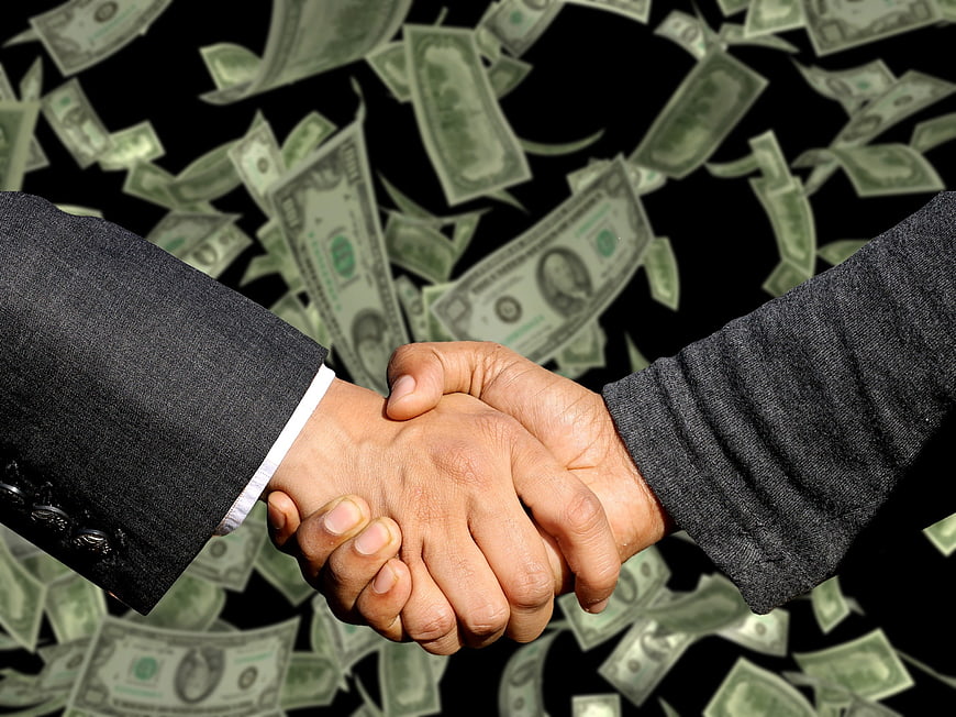 Business handshake with falling money background