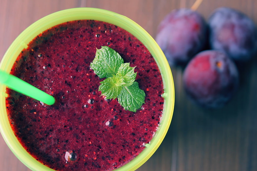 Top-Down View of Plum Smoothie Garnished with Mint Leaves